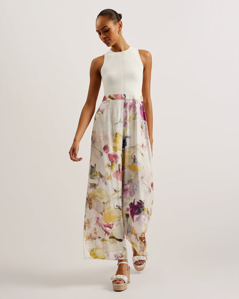 TIRSSO-Trousers-Switch up your special occasion fits with the TIRSSO jumpsuit. The top and trousers illusion brings effortless style, pairing a sleeveless bodice with wide leg bottoms for a flattering fit. The simple knitted top is elevated by a crossover neckline, and contrasts against the floral print of the trousers which adds a delicate pop of colour. Sleeveless jumpsuit Top and trousers illusion Pressed flower print Ribbed knit fitted bodice Crossover halter neck Wide leg trousers Exposed zip fastening